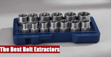 Heavy-duty bolt extractor set organized in an open toolbox resting on a rough gray cement floor surface.
