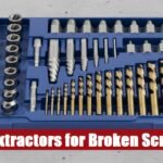 Professional broken screw extractor tool set case lying on a rough grey cement floor for workshop repairs.