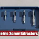 Heavy duty metric screw extractor set toolbox lying on a rough gray cement floor in a garage workshop.